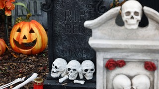 Kürbisse und Skelette: Halloweendeko in einem Garten vor einem Wohnhaus (Symbolbild)