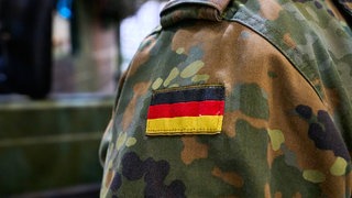 Ein Bundeswehrsoldat in Tarnuniform mit der deutschen Flagge als Abzeichen auf der Schulter. (Symbolbild)