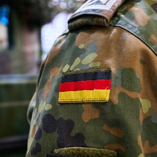 Ein Bundeswehrsoldat in Tarnuniform mit der deutschen Flagge als Abzeichen auf der Schulter. (Symbolbild)
