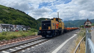 Seit Mitte Juni 2025 liegen wieder Schienen in Dernau. Sie waren bei der Flutkatastrophe 2021 weggerissen worden. Ein Bauzug hat auf den neuen Gleisen Schwellen und Oberleitungsmasten ins Ahrtal gebracht.