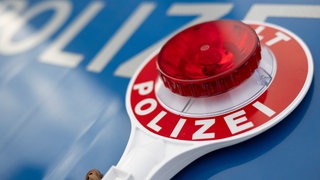 Eine Polizeikelle liegt auf einem Einsatzfahrzeug der Polizei: In einer Klinik in Bad Neuenahr-Ahrweiler wird ein 31 Jahre alter Mann vermisst.
