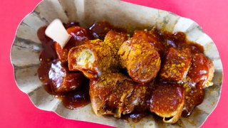 Eine Currywurst, so wie man sie kennt - mit Tomatensauce und Currypulver: Beim Currywurstfestival in Neuwied 2026 kann man unzählige weitere Variationen kosten.