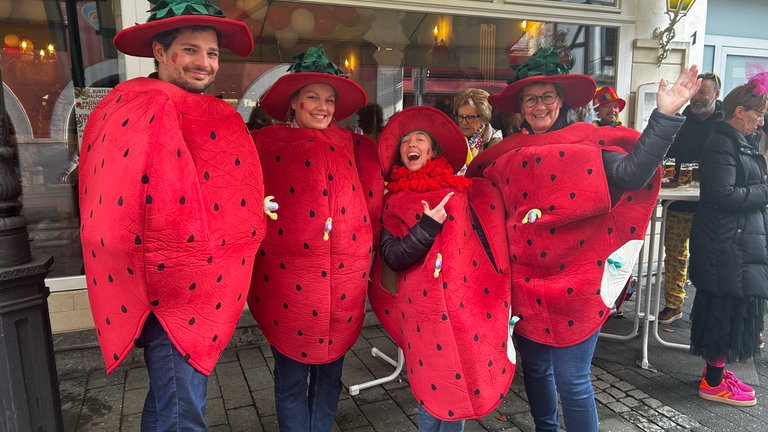 Eine Truppe mit Ganzkörper-Erdbeeren-Kostümen.