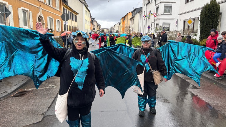 Eine Fußgruppe mit großen blauen Drachenflügeln