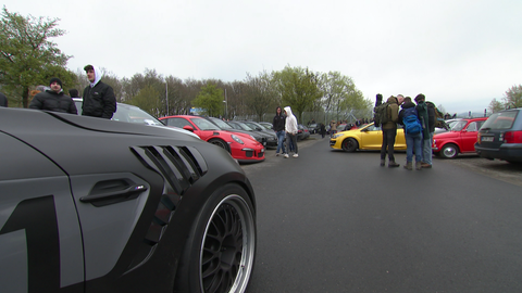 Tuningfans stehen am "Carfriday" auf der Rennstrecke am Nürburgring vor Porsche und Co.