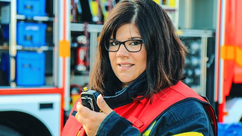 Feuerwehrfrau Nicole Werner mit Gruppenführer-Weste und Funkgerät in der Hand