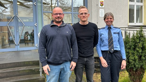 Polizeiverhandler Benedikt Teuchler steht zusammen mit zwei Kollegen vor der Polizeiinspektion Neuwied.