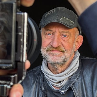 Ein Mann wird von einem professionellen Fotografen abgelichtet.