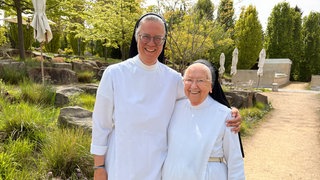 Schwester Ursula und Schwester Irmingard stehen im Garten der Arenberger Dominikanerinnen in Koblenz-Arenberg