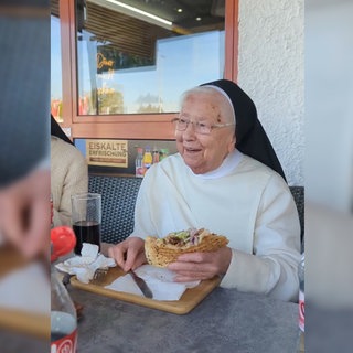 Schwester Irmingard hält ihren ersten Döner in der Hand