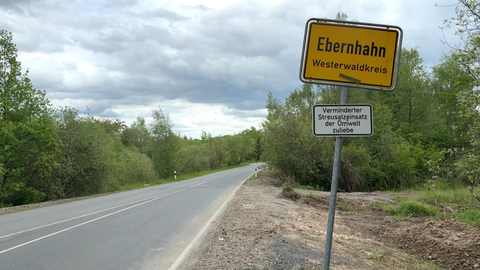 Ortsschild von Ebernhahn an einer Straße