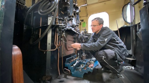 Techniker Andreas Thiel erledigt im Führerhaus letzte Arbeiten an der alten Dampflok der Brohltalbahn. 