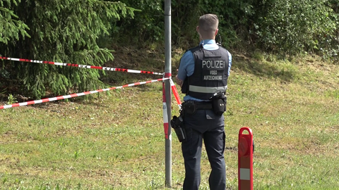 Ein Polizist in der Nähe des Ortes, wo die mutmaßlich getötete Frau in ihrem Wagen gefunden wurde. Die 29-Jährige aus Wirft starb an mehreren Stichverletzungen.