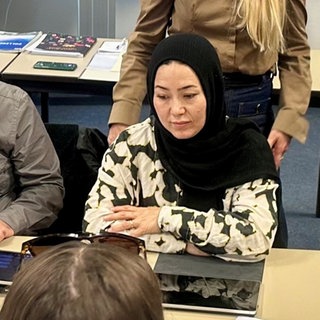 Teilnahme am Integrationskurs: Eine Frau mit Kopftuch und ein Mann sitzen am Schreibtisch und lernen.
