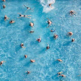Zahlreiche Badegäste sind in einem Freibad im Wasserbecken (Aufnahme mit einer Drohne).