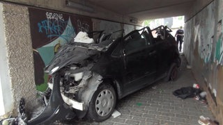 Schwer beschädigtes Autowrack in einer Fußgängerunterführung in Andernach - der Fahrer verstarb später im Krankenhaus.