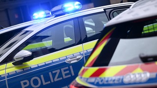 Mehrere Polizeiautos stehen mit eingeschaltetem Blaulicht nebeneinander