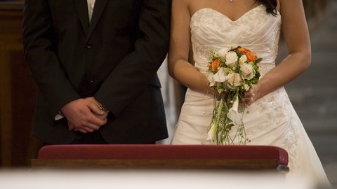 Ein Brautpaar steht mit Blumen vor dem Traualtar: Pop-Up-Hochzeiten für Kurzentschlossene in Ludwigshafen