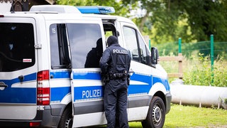 Polizist vor Einsatzwagen