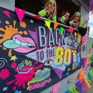 Ein kunterbunter Fastnachtswagen im Stil der 80er Jahre beim Faschingsumzug in Neuburg: 2025 gibt es in der Pfalz fast 30 Fastnachtsumzüge