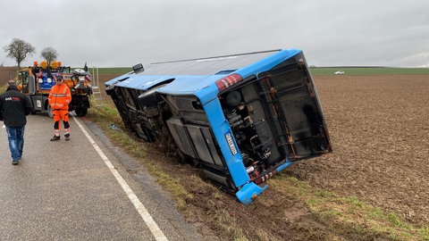 Der verunglückte blaue Linienbus von hinten. In dem Linienbus saßen drei Fahrgäste und der Busfahrer. Alle blieben bei dem Unfall unverletzt.