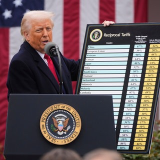 Donald Trump hält eine großes Schild mit den angedachten Zöllen hoch, auch Unternehmen der Pfalz werden von den Strafzöllen betroffen sein. 