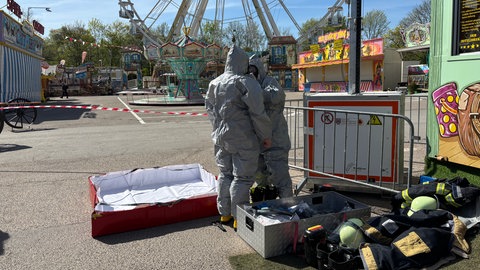 Hier ziehen sich Einsatzkräfte Schutzanzüge während der Katastrophenschutzübung auf der Frühjahrsmesse in Speyer an.
