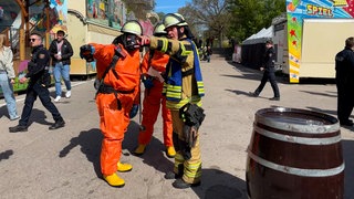 Einsatzkräfte mit Schutzkleidung auf der Frühjahrsmesse in Speyer während einer Katastrophenschutzübung.