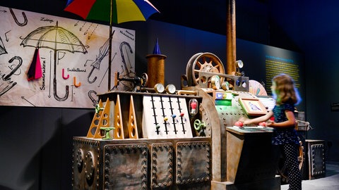 Im Historischen Museum der Pfalz in Speyer probiert ein Mädchen eine Maschine aus. In dem Museum gibt es immer wieder spezielle Ausstellungen und Aktionen für Kinder