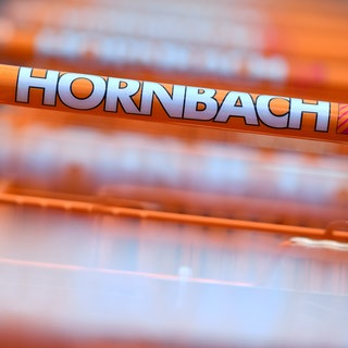 Das Hornbach-Logo auf einem Einkaufswagen. Im Geschäftsjahr 202425 konnte das Unternehmen den Umsatz leicht steigern.