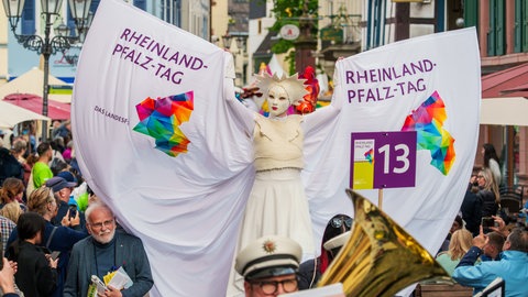 Eine bunte Parade aus Fuss- und Musikgruppen zieht durch die Innenstadt von Neustadt an der Weinstraße beim Rheinland-Pfalz-Tag.