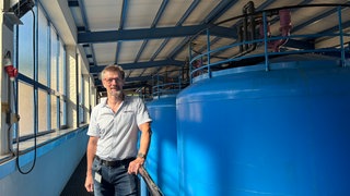 Rainer Barchet vor Wasserpumpe