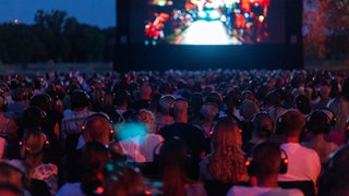 Zuschauerinnen und Zuschauer schauen sich einen Film beim Festival des deutschen Films in Ludwigshafen an. Archivbild. In Ludwigshafen haben die Aufbauarbeiten für das Festival des deutschen Films 2025 begonnen.