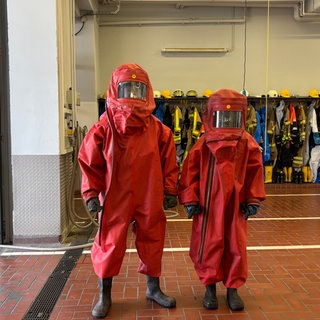 Zwei Azubis der Werkfeuerwehr BASF im roten Schutzanzug