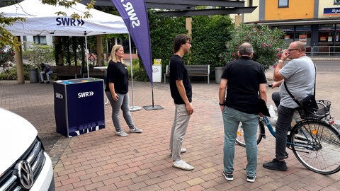 SWR Aktuell vor Ort in Schifferstadt - Reporter Leon Vucemilovic und Frank Schumann im Gespräch mit einem Passanten.