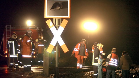 Feuerwehrleute und Polizei sichern in der Nacht zum Dienstag (02.03.2004) am Unglücksort bei Süsel (Kreis Ostholstein) die Unfallstelle. Zwei Rollstuhlfahrer sind an einem unbeschränkten Bahnübergang ums Leben gekommen.