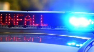 Schriftzug "Unfall" leuchtet auf einem Polizeiauto (Symbolbild)