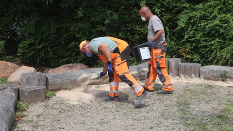 Zwei Arbeiter bringen in Landau Kieselgur aus.