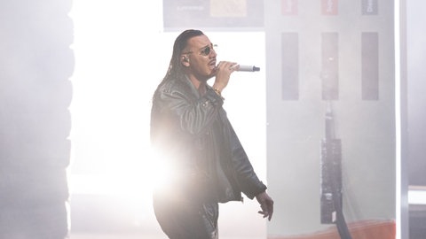 Der deutsche Rapper und Sänger Apache 207 tritt auf einer Bühne auf (Symbolbild). Er stellte sein neues Album im Plopsaland in Haßloch vor.