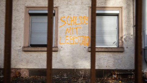 Leerstehende Wohnung von außen mit runtergelassenen Rolläden mit Graffiti (Symbolbild). Frankenthal geht gegen Leerstände vor.
