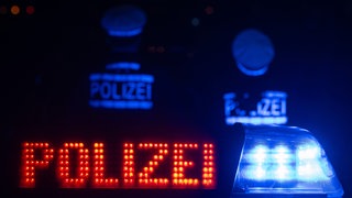 Polizeiwagen und zwei Polizisten in der Nacht (Symbolbild). 16-Jähriger schnappt sich Mamas Auto und baut Unfall 