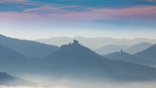 Herbstliches Panorama vom Pfälzerwald mit Berggipfeln und Tälern im Nebel. In der Bildmitte sieht man die Burg Trifels bei Annweiler - Bild für Artikel: Schatzsuche mit App in Südpfälzer Burgen