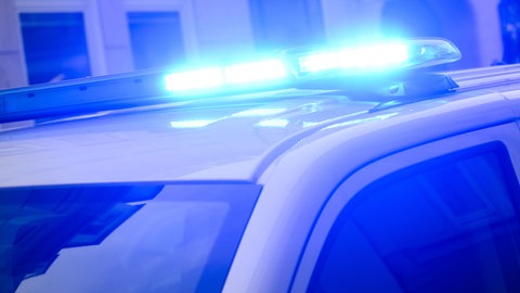 Blaulicht eines Polizeiwagens im Dunkeln, Symbolbild für jungem Mann wird mit Reizgaspistole aufs Auge geschossen in Germersheim