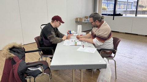 Mark Blattner von der Aids-, Drogen- und Jugendhilfe Landau ist beim Welt-AIDS-Tag zum zweiten Mal auf dem Campus der Universität in Landau. Dort bietet der Psychologe Beratung und vor allem: kostenlose HIV-Tests. Hier ist zu sehen, wie Blattner (rechts) einen Studierenden (links) testen.