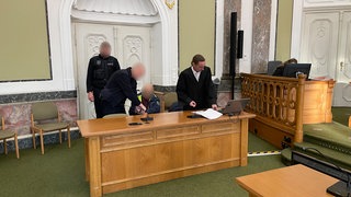 Der Angeklagte im Prozess am Landgericht Landau. Er hat im Juli Feuer in einer Sparkassen-Filiale in Germersheim gelegt und muss in ein psychiatrisches Krankenhaus. Das Landgericht Landau findet, dass der Rentner noch immer gefährlich für sich und andere sein könnte.