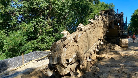 Der Spezialbagger arbeitete senkrechte Wände aus Beton und Erde in den Bahndamm hinein.