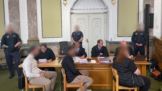 Drei Angeklagte und deren Verteidiger am Montag vor der großen Strafkammer am Landgericht Landau.