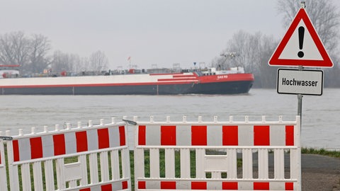 Ein Schild warnt vor Hochwasser am Rhein. Die Vorder- und Südpfalz und Ludwigshafen sind besonders stark von den Folgen des Klimawandels bedroht.