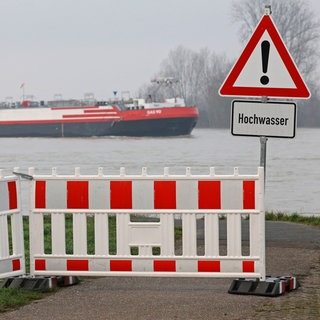 Ein Schild warnt vor Hochwasser am Rhein. Die Vorder- und Südpfalz und Ludwigshafen sind besonders stark von den Folgen des Klimawandels bedroht.