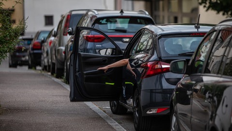 Ein Mann schließt die Tür eines Autos
